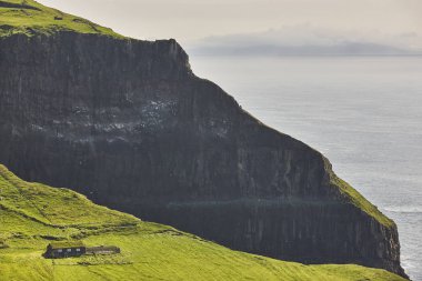 Mykines geleneksel çim ev ile dramatik uçurumlar. Faroe 