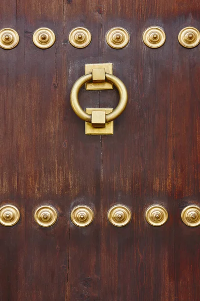 Botão de porta clássico de bronze antigo em uma porta de madeira — Fotografia de Stock