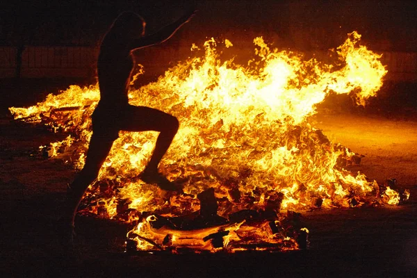 Summer solstice celebration in Spain. Woman jump. Fire flames — Stock Photo, Image