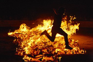 Summer solstice celebration in Spain. Jumping into the fire. clipart