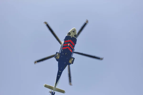 Aşağıdan mavi bir gökyüzünün altında uçan helikopter. Taşıma — Stok fotoğraf