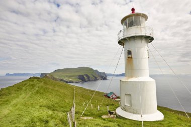 Faroe adalarındaki Mykines deniz feneri ve kayalıklar. Yürüyüş noktası
