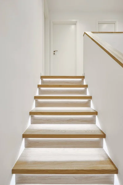 Home interior with stylish wooden iluminated staircase white wal — Stock Photo, Image