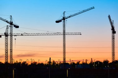 Gün batımında turnalar. İnşaat devam ediyor. İnşaat endüstriyel makineleri