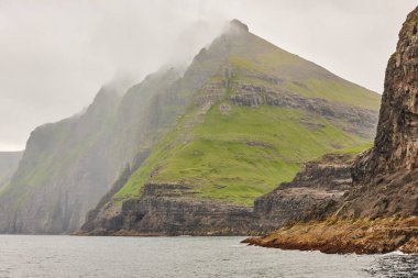 Faroe adalarındaki yeşil kayalıklar ve Atlantik Okyanusu. 