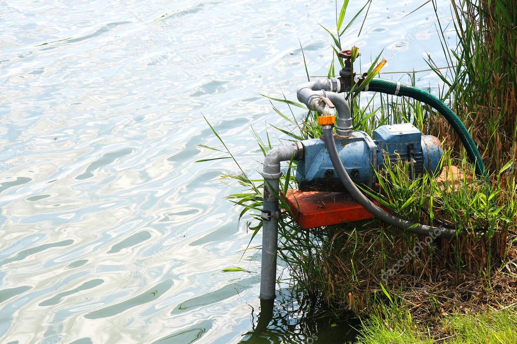 Water pump working in the lake's shore to maintenance the water.