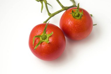 Beyaz arka plan üzerinde izole yaprak ile iki domates. Bir madde veya lezzetli yemekler için garnitür olarak mutfak sebze domates botanik berry tipi meyve olmakla birlikte, olarak kabul edilir.