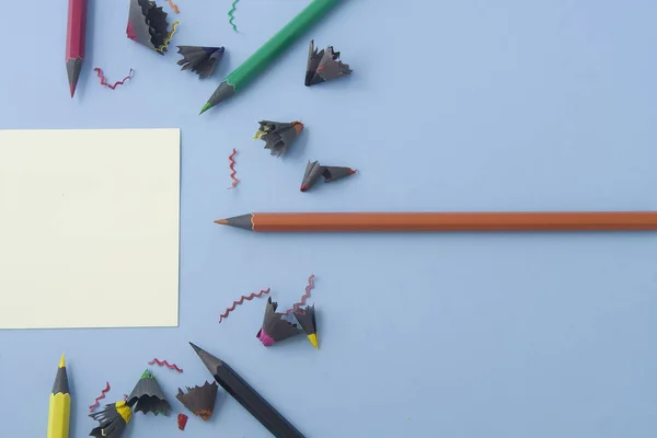Crayons Colorés Organisés Autour Une Note Isolée Sur Bleu Clair — Photo