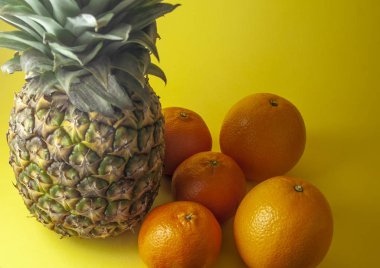 Tek ananas portakal ve mandalina portakal sarı zemin üzerine izole.