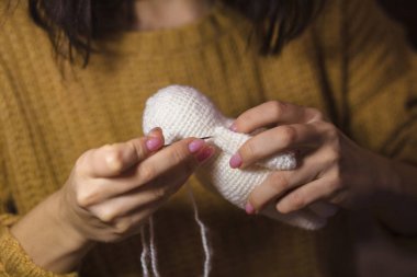 Bir beyaz ayı yapma. Örgü oyuncak bir çocuk için. İğne Mika elinde. Yürüyerek dikmek. El sanatları el yapımı. Benlik kavramı. Küçük işletme. Hobi gelir