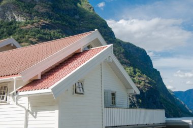 Beyaz ahşap evin yakınındaki Aurlandsfjord, Flam (Aurlandsfjorden), Norveç güzel dağlar kırmızı çatılı