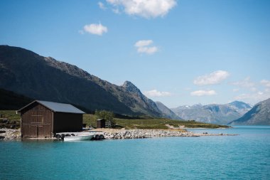 ahşap ahır ve tekne kıyısında görkemli Gjende Gölü, Besseggen sırtı, Jotunheimen Milli Parkı, Norveç