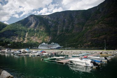 AURLANDSFJORD, FLAM, NORWAY - 27 JULY, 2018: boats moored in harbour and beautiful mountains at Aurlandsfjord, Flam (Aurlandsfjorden), Norway clipart