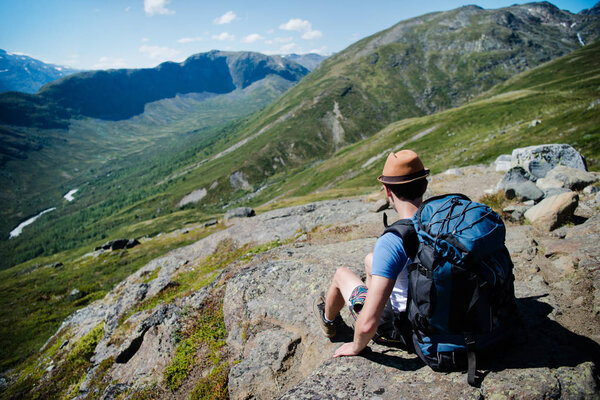 Путешественник с рюкзаком отдыхает на хребте Бессегген в Национальном парке Йотунхеймен, Норвегия
