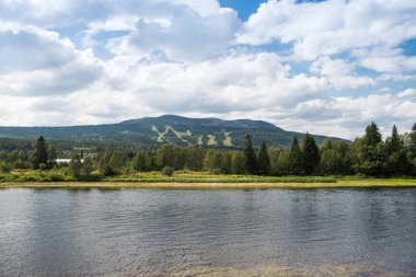 aerial view of river, trees and mountains, Trysil, Norway's largest ski resort  clipart