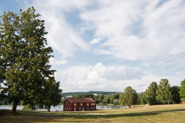 Kırmızı ev yakın göl altında bulutlu gökyüzü, Hamar,: Hedmark, Norway