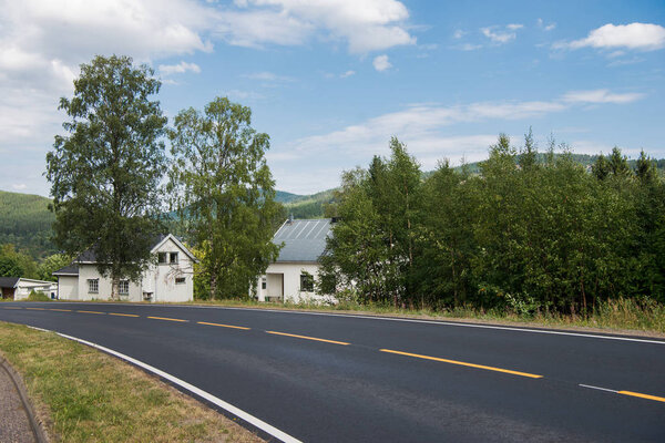 road with side buildings and green trees, Trysil, Norway's largest ski resort 