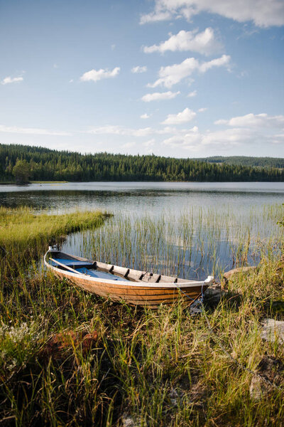 wooden boat near lake in front of forest in Trysil, Norway's largest ski resort 