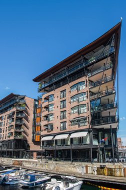 OSLO, NORWAY - 28 JULY, 2018: modern houses and boats at shipyard, Aker Brygge district, Oslo  clipart