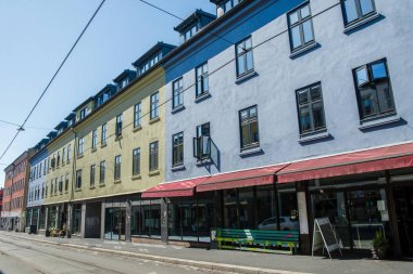 beautiful bright buildings and empty street at sunny day, oslo, norway clipart