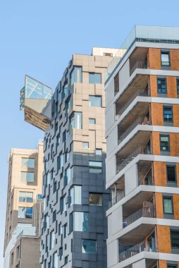 low angle view of beautiful modern buildings against blue sky at Barcode district, Oslo  clipart