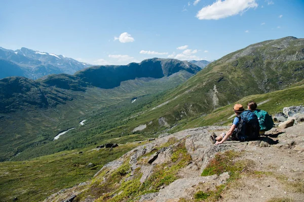 Pareja de excursionistas sentados en la cresta de Besseggen en el Parque Nacional Jotunheimen, Noruega - foto de stock