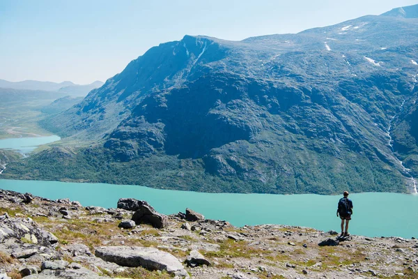 Escursionista in piedi sulla cresta di Besseggen e guardando il lago Gjende nel Parco Nazionale di Jotunheimen, Norvegia — Foto stock