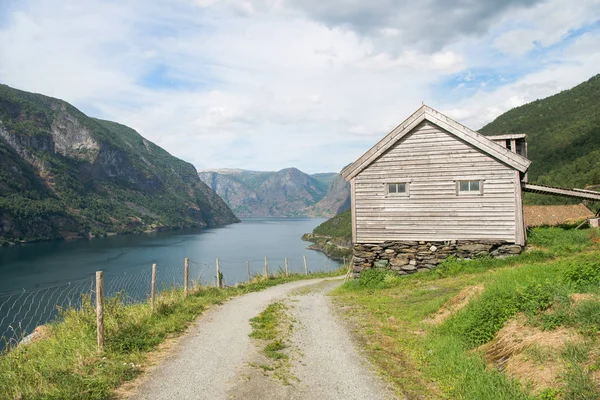Route rurale et maison en bois au majestueux Aurlandsfjord, Flam (Aurlandsfjorden), Norvège — Photo de stock