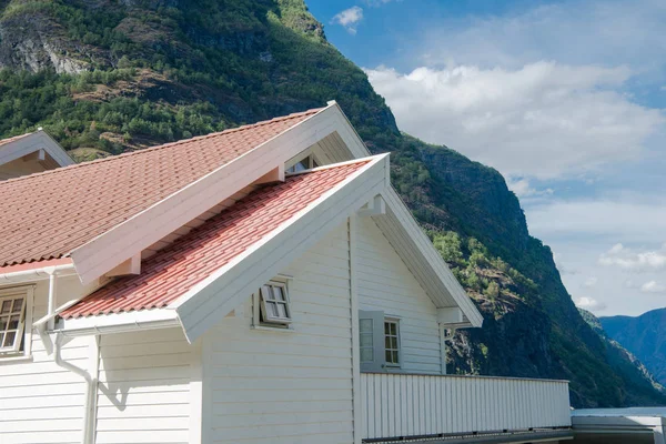 Casa de madeira branca com telhado vermelho perto de belas montanhas em Aurlandsfjord, Flam (Aurlandsfjorden), Noruega — Fotografia de Stock
