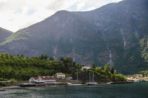 Edifícios e iates ancorados em lago calmo perto de belas montanhas na Noruega — Fotografia de Stock