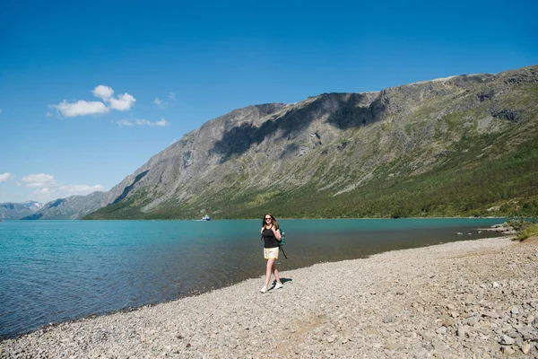 Belle jeune femme avec sac à dos marchant près du lac de Gjende, crête de Besseggen, parc national de Jotunheimen, Norvège — Photo de stock