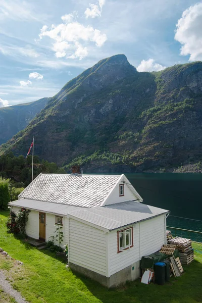 AURLANDSFJORD, FLAM, NORVÈGE - 27 JUILLET 2018 : vue en angle élevé de la maison blanche confortable et des montagnes majestueuses à Aurlandsfjord, Flam (Aurlandsfjorden), Norvège — Photo de stock