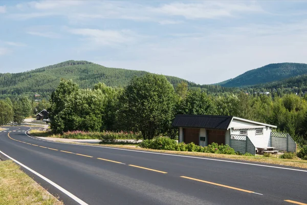 Road with side building and green hills, Trysil, Norway's largest ski resort — Stock Photo