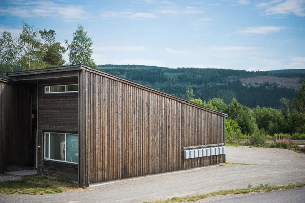 Bâtiment en bois avec montagne verte sur fond, Trysil, la plus grande station de ski de Norvège — Photo de stock