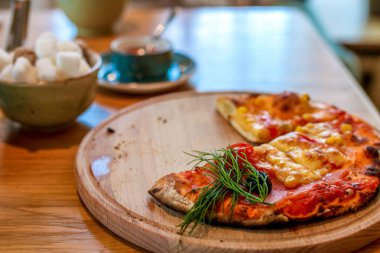 Gevrek ev yapımı Pizza Margherita veya arkadaki (seçici odak, odak üçte biri haline ilk pizza malzemelerle ahşap plaka üzerinde Pizza Mozzarella (domates, fesleğen ve peynir pizza))