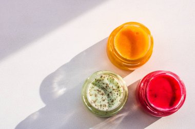 Çok renkli reçel ve bal beyaz arka plan üzerinde izole üç kavanoz. Kırmızı yeallow ve yeşil sıkışmaları.