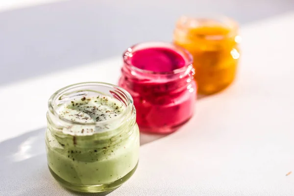 Three jars of colorful jams. Green red and yeallow honey souffle. — Stock Photo, Image