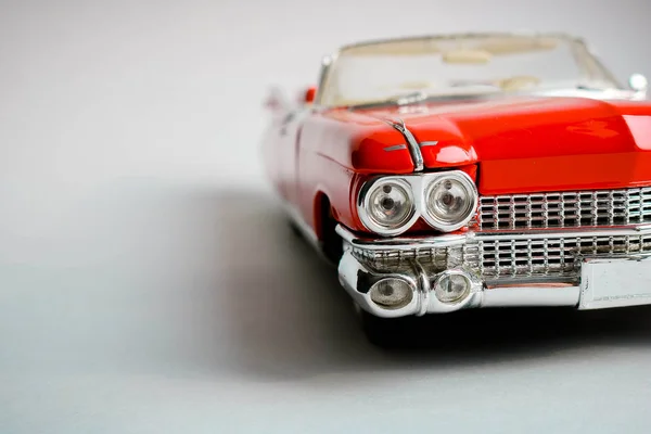 Collectible red toy car model on the white background. Close up view. American classic car 1959.