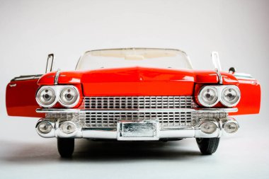 Amerikan klasik kırmızı arabanın ön görünümünü kapatın. Beyaz arka planda gerçekçi ölçek araba modeli.