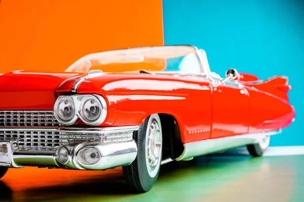 Hood ve farlar görünümü yakın. Antika Amerikan kırmızı araba. Renkli arka planda ölçek modeli.