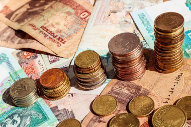 Büyüme grafiği şeklinde sikke yığınları. İş konsepti. Banknotlar ile arka plan.