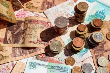 Kağıt notları üzerinde sikke yığınları. Banknotlar ve farklı ülkelerin paraları.