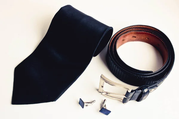 Top view of luxury men 's accessories. Черный шелковый галстук, черный кожаный ремень и запонки . — стоковое фото
