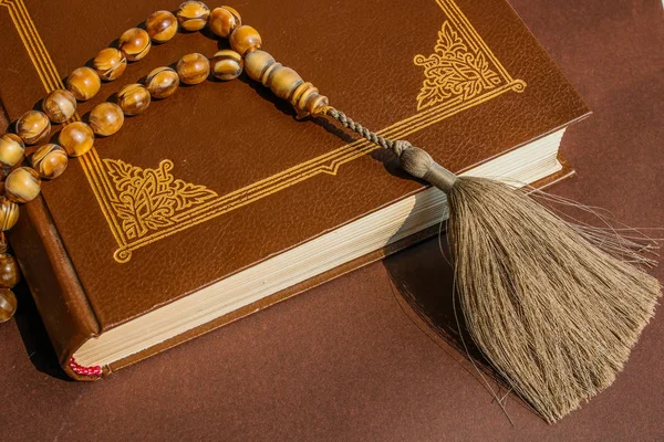Kur'an-ı Kerim'de otantik İslam tesbihi. Brown Kutsal kitap ve broun arka plan. Dini kavram. — Stok fotoğraf