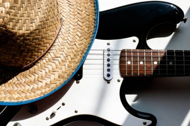 Elektronik gitarda kovboy şapkası. Beyaz arka plan. Country müzik konsepti veya arka plan. Amerikan kültürü.