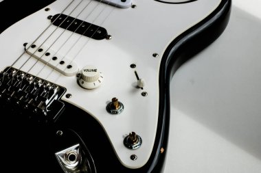 Elektronik gitar gövdesi detayları kapatın. Doğal ışık ve gölgeler ile beyaz arka plan üzerinde elektronik gitar.