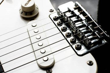 Elektronik siyah beyaz gitar gövdesi pikaplar ve kontrol düğümleri ile kapatın.