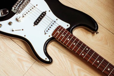 Ahşap zeminde elektrobik gitar. Gitar gövdesi ile müzik konsepti.