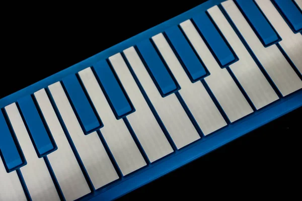 Piano electrónico moderno con teclas azul y blanco sobre fondo negro. Instrumento musical . — Foto de Stock