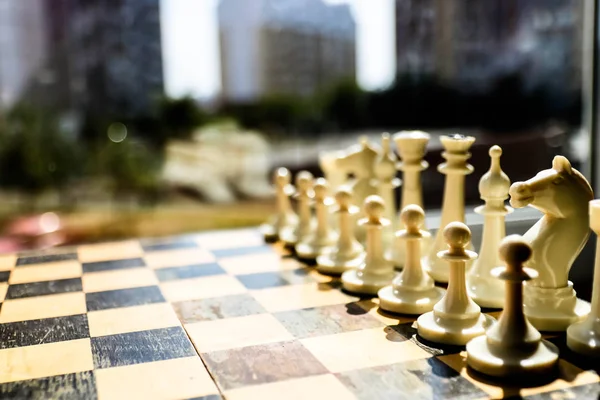 Piezas de ajedrez blancas en un tablero de ajedrez y mundo abierto sobre fondo borroso. Concepto de trabajo en equipo para los éxitos . —  Fotos de Stock